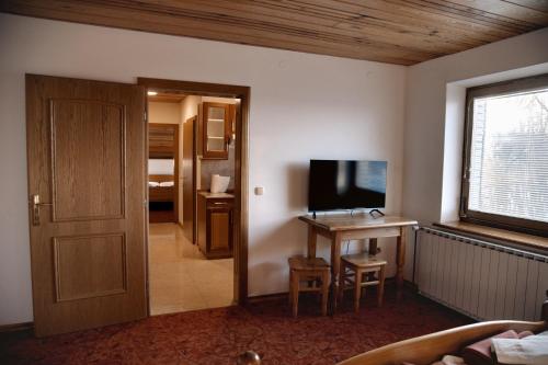 摩拉瓦托普利采畔可儿旅馆的客房设有电视和带书桌的桌子