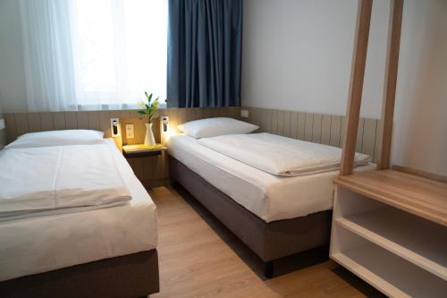 博尔滕哈根BEECH Resort Boltenhagen的小型客房 - 带2张床和窗户