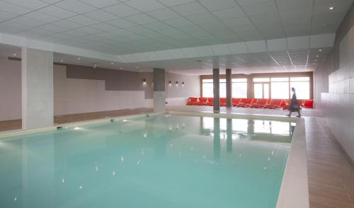圣福瓦-塔朗泰斯科丽特迪斯赛姆公寓式酒店的游泳池,在有人行走的房间