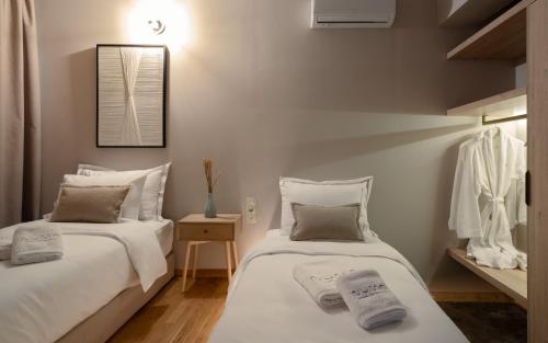 雅典Numa Suites & Lofts Athens的白色墙壁客房的两张床