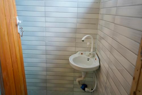 达累斯萨拉姆2 Bedroom spacious Cozy Home in Kigamboni,10 min Walk to Beach的浴室铺有白色瓷砖,配有白色水槽。