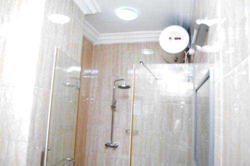 哈科特港Golden Tulip Hotel -GT31 Stadium Road的带淋浴的浴室和玻璃门