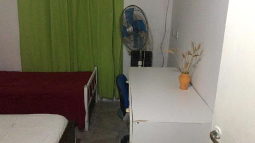 Gualeguaychúdepartamento gualeguaychu的客房设有一张床、一张书桌和风扇