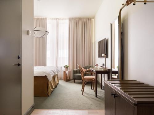 哈尔姆斯塔德Elite Hotel Mårtenson的配有一张床和一张书桌的酒店客房