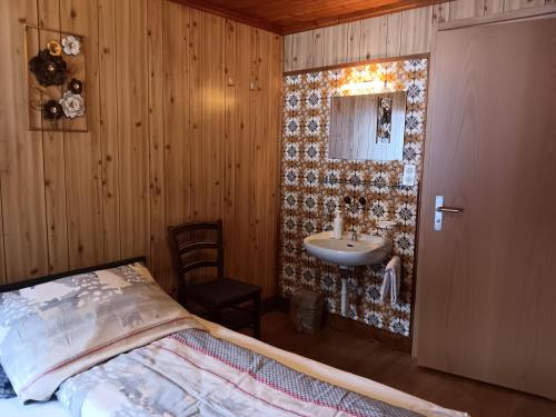 萨斯阿尔马格尔Pension Waldegg - restaurant的卧室配有水槽,卧室配有一张床