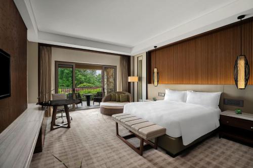 安吉县安吉JW万豪酒店的一间带大床的卧室和一个阳台