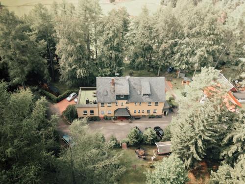 坦巴赫-迪塔尔茨Thüringer Waldbaude的树林中房屋的空中景观