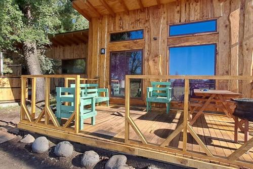 洛斯安赫莱斯Hospedaje Andes的小屋设有椅子和一张桌子,位于甲板上