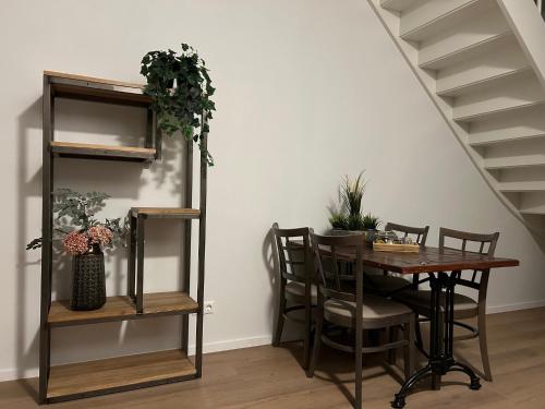 NijeveenHotel Nijeveen的一间带桌椅和楼梯的用餐室