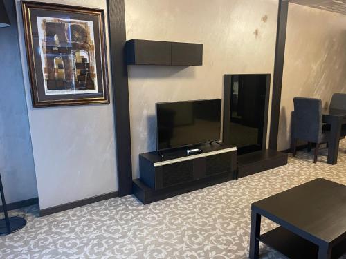 韦林格勒Мия 2 Deluxe Royal Spa的客厅配有平面电视和桌子。