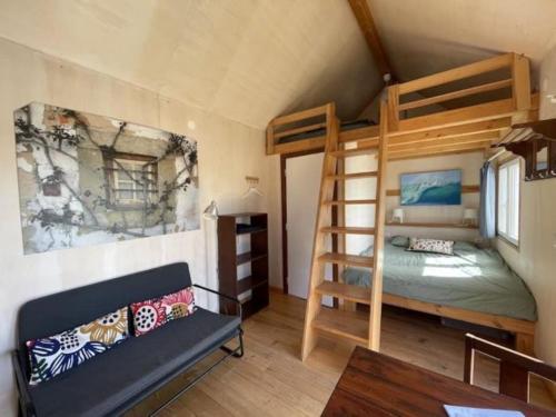 劳林哈Da Silva Surfcamp, Tiny House Luna的一间卧室配有双层床和沙发