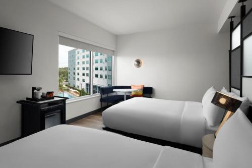奥兰多Aloft Orlando International Drive的酒店客房设有两张床和窗户。