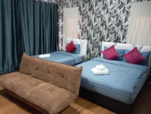 Ban KoKhokeng Room的两张带枕头的床和一张沙发