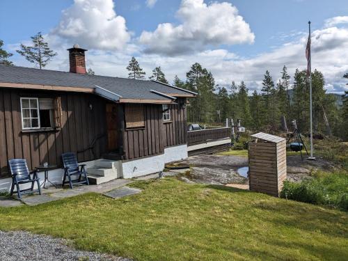 康斯博Turibu - cabin in a nice hiking and skiing area的房屋外有两把椅子