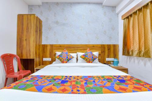 艾哈迈达巴德FabHotel Star的一间卧室配有一张大床和色彩缤纷的被子