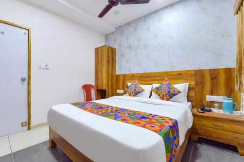 艾哈迈达巴德FabHotel Star的一间卧室配有一张大床和木制床头板