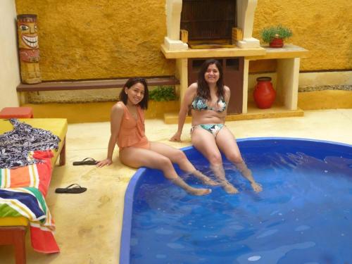 蓬塔赫尔莫萨Hospedaje Punta Hermosa的两个穿着泳衣的女人坐在游泳池里
