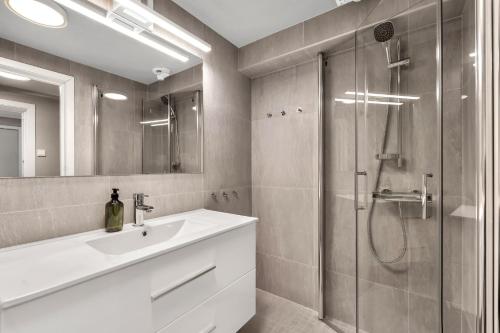 特罗姆瑟Bispegata 5 - Studio Apartment hotel的带淋浴、盥洗盆和镜子的浴室