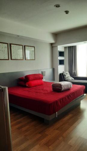斯勒曼Apartment Mataram City Yogyakarta的一张床上,床上有红色的床单和枕头