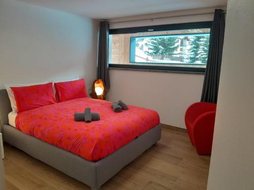 瓦托内切Casa Lo Tzé Relais - Indipendent house with amazing view的一间卧室配有一张带红色床单的床和一扇窗户。