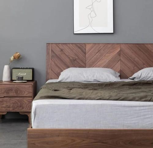 勒克瑙Osho homes的一间卧室配有一张大床和木制床头板