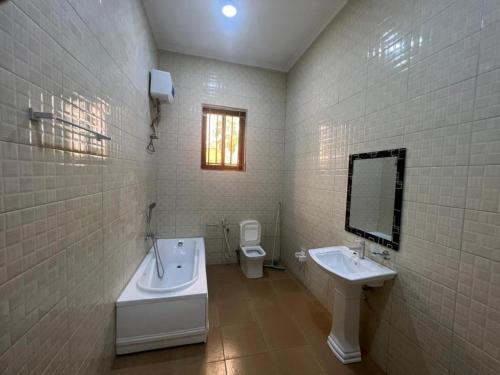 达累斯萨拉姆J & S LUGALLA HOUSE的带浴缸、盥洗盆和卫生间的浴室