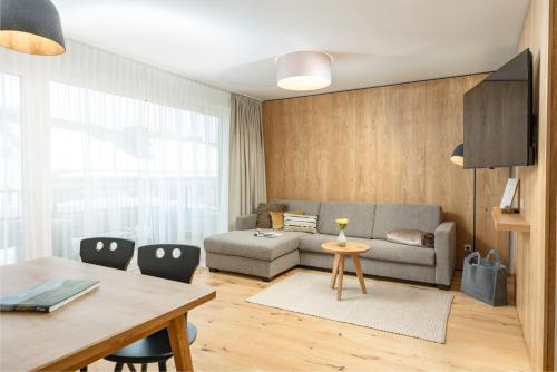 斯拉德明Aparthotel Ursprung的客厅配有沙发和桌子