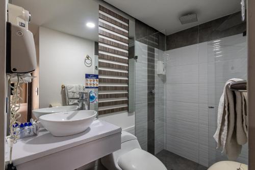 麦德林Hotel Torre Poblado的一间带两个盥洗盆和淋浴的浴室