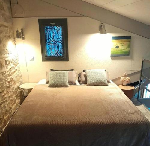 阿尔布瓦假日阁楼58度假屋的卧室配有一张大床,墙上挂有绘画作品