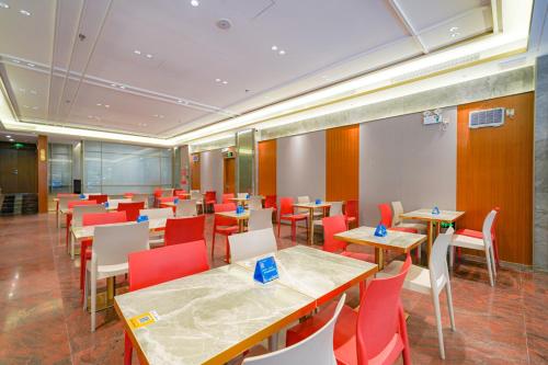 广州广州白云城市酒店的餐厅设有木桌和红色椅子