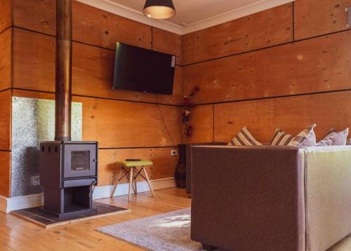 巴拉斯港Casa loft con opción de tina temperada的客厅配有电视、沙发和炉灶。