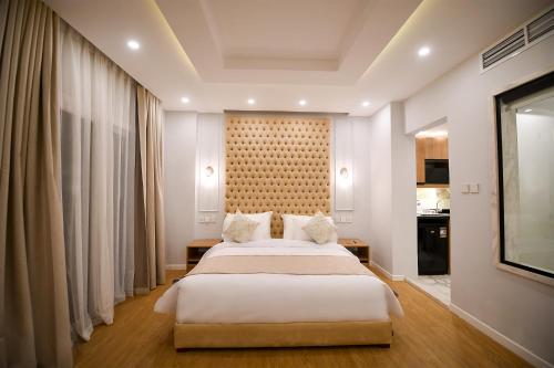 开罗Arabella Premium Residence - New Cairo的卧室配有一张白色大床和一堵墙