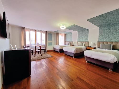 阿雷基帕帆迪朵酒店的酒店客房设有两张床和一张桌子。