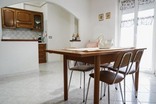 丰尼L Agrifoglio di Rita Loddo的厨房配有木桌和四把椅子
