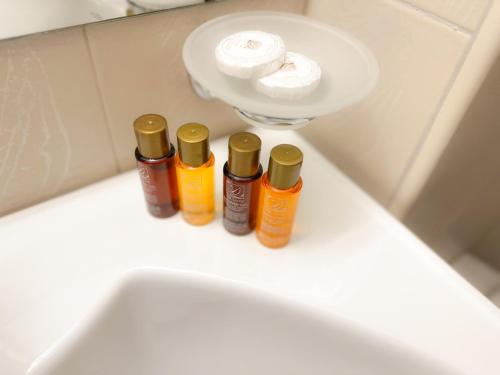 班斯科IZ VIEW Apartment的三个瓶装精油坐在浴室水槽顶部