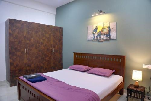 海得拉巴Veetil -3BHK A/C, Kukatpally, Hyderabad的一间卧室配有一张带紫色枕头的大床