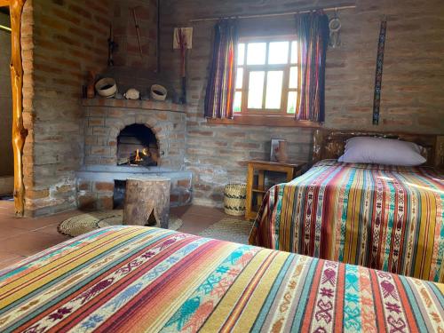 科塔卡奇Kallpa Wasi的一间卧室配有一张床和一个石头壁炉