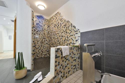 特罗德纳Hotel Ludwigshof & Luvina的一间带淋浴的浴室和瓷砖墙