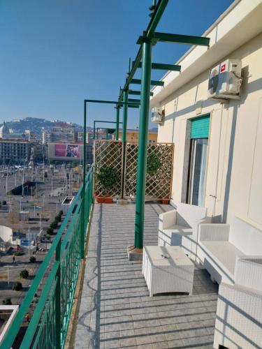 那不勒斯Attico Central Station Napoli的阳台配有白色椅子,享有城市美景