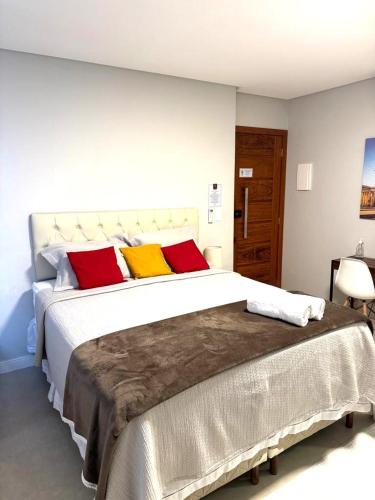 多明戈斯马丁斯Canto Alemão的一间卧室配有一张大床,提供红色和黄色枕头
