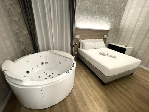 罗马ROME'S GLORIA HOTEL的卧室配有浴缸,位于床边