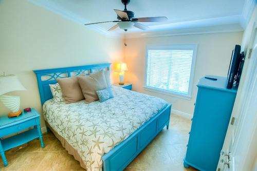 霍姆斯海滩Island Escape的一间卧室配有蓝色的床和吊扇