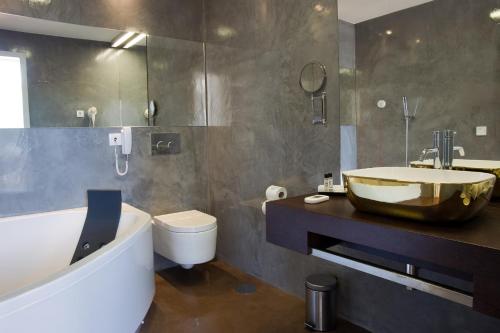 吉尔斯Hotel São Bento da Porta Aberta & Spa的一间带水槽、浴缸和卫生间的浴室