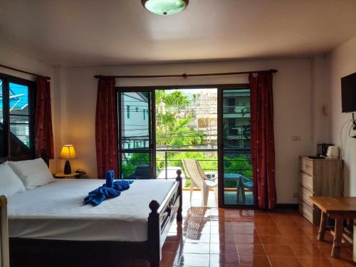 卡塔海滩Kata Lina guesthouse的一间卧室设有一张床和一个滑动玻璃门