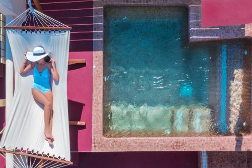 安坡里奥圣托里尼Luxury Villas Hariton的坐在游泳池旁的吊床上的女人