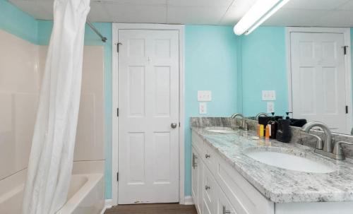 默特尔比奇4800 S Ocean Blvd, 0915 - Ocean Front Sleeps 6的浴室设有两个水槽和蓝色的墙壁。