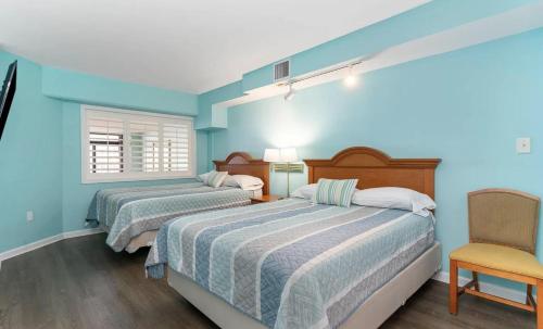 默特尔比奇4800 S Ocean Blvd, 0915 - Ocean Front Sleeps 6的配有两张床铺的蓝色墙壁和椅子