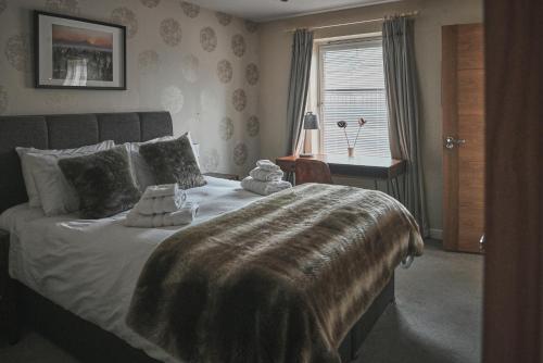 阿维莫尔The Steadings, Aviemore Luxury 5 star rated 3 Bed with home cinema garden and parking的一间卧室设有一张大床和一个窗户。