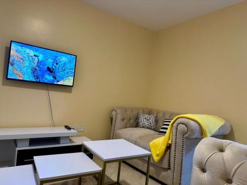 ThikaCandy's Staycation的带沙发和平面电视的客厅