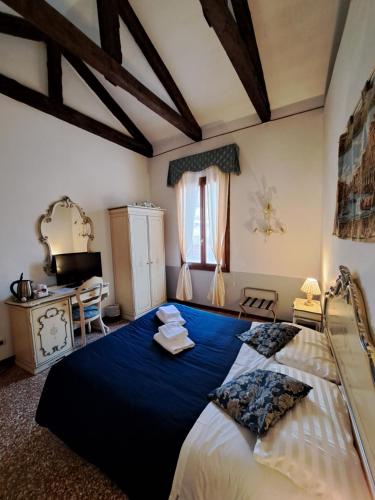 威尼斯洛坎达卡弗摩萨酒店的一间卧室配有一张带蓝色床单的大床